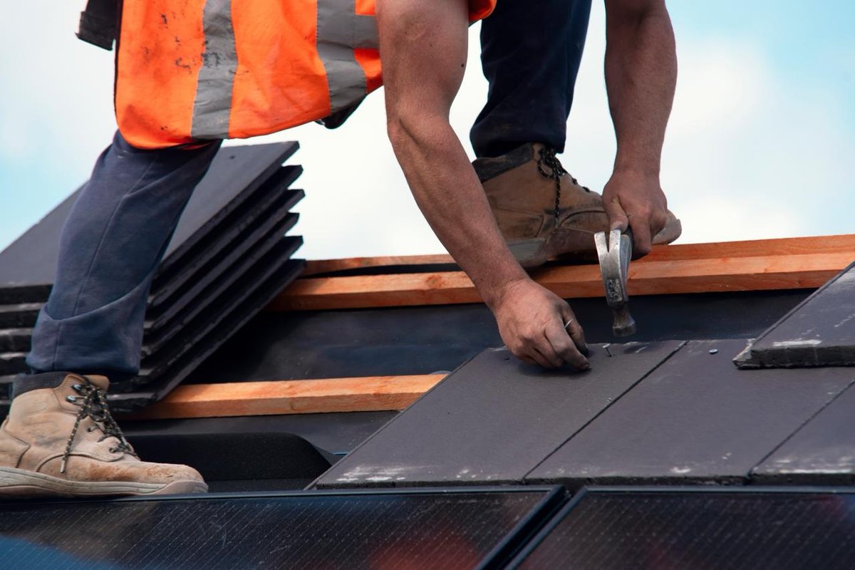 Professional roofer installing shingles